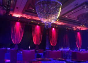 Red Velour Red Velvet Drapery Bellows with a Custom Beaded Chandelier Rented and Setup By Turn of Events Productions Las Vegas