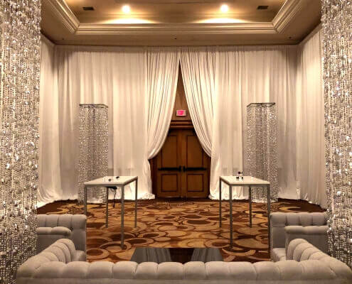 Beaded Silver Columns inside a white velour / white velvet draped room From Turn of Events Las Vegas Rental Drapery